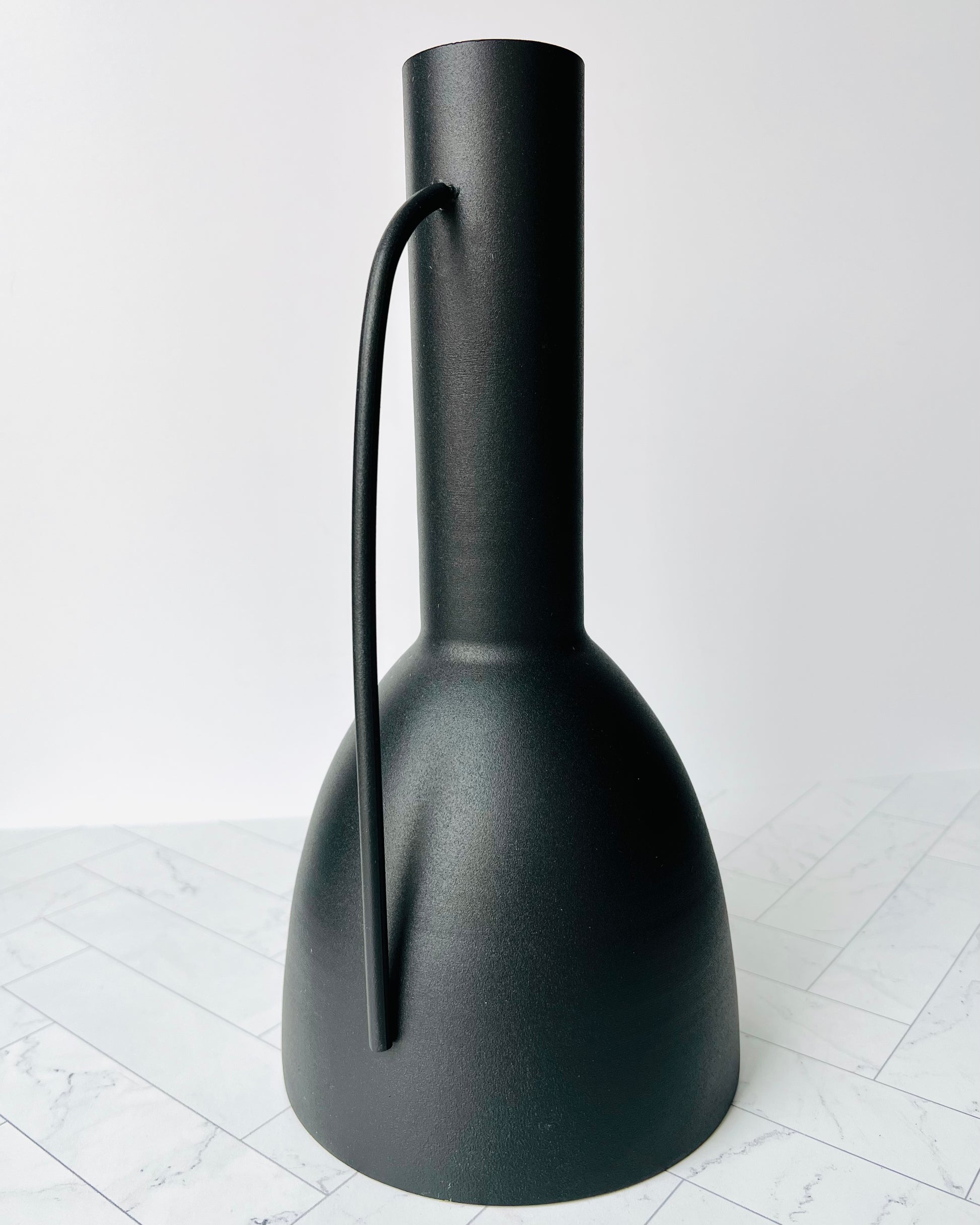 The Sleek Black Vase with its handle facing toward the camera to show it off