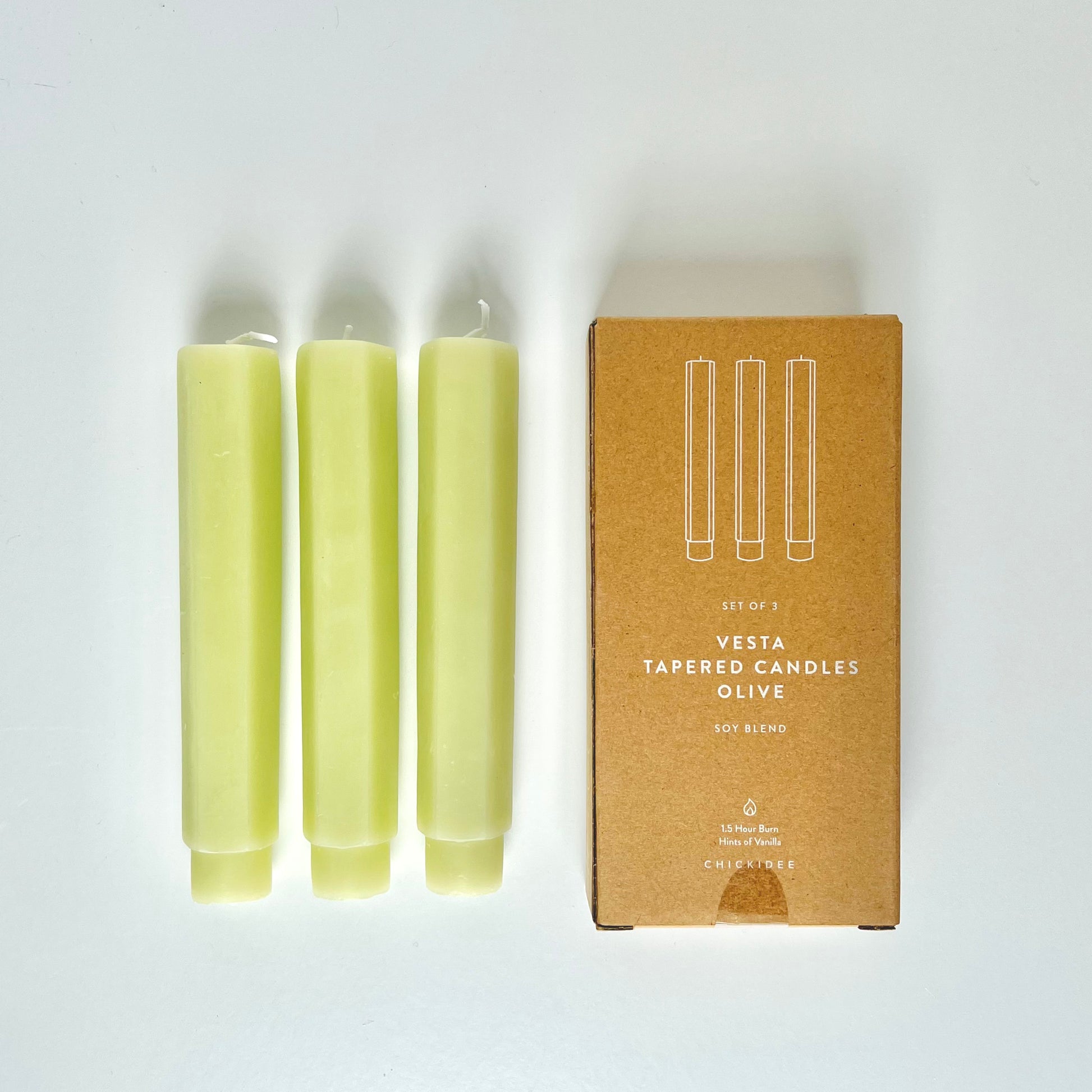Three melon taper candles shown from overhead with their brown cardboard box next to them