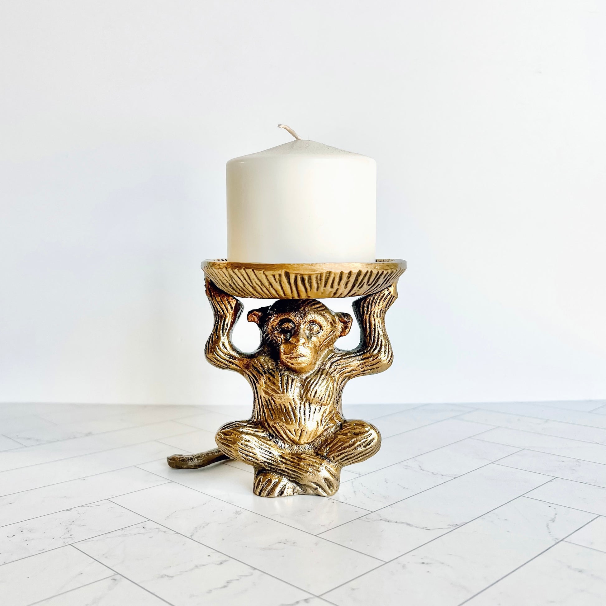 The brass animal figurine shown holding a pillar candle