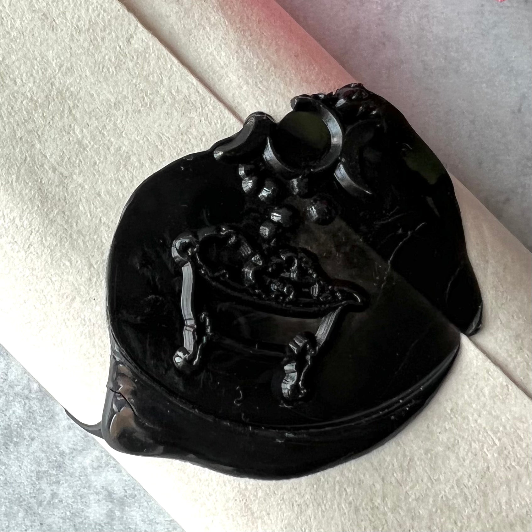 A close up of the black wax seal of the taper candles' label