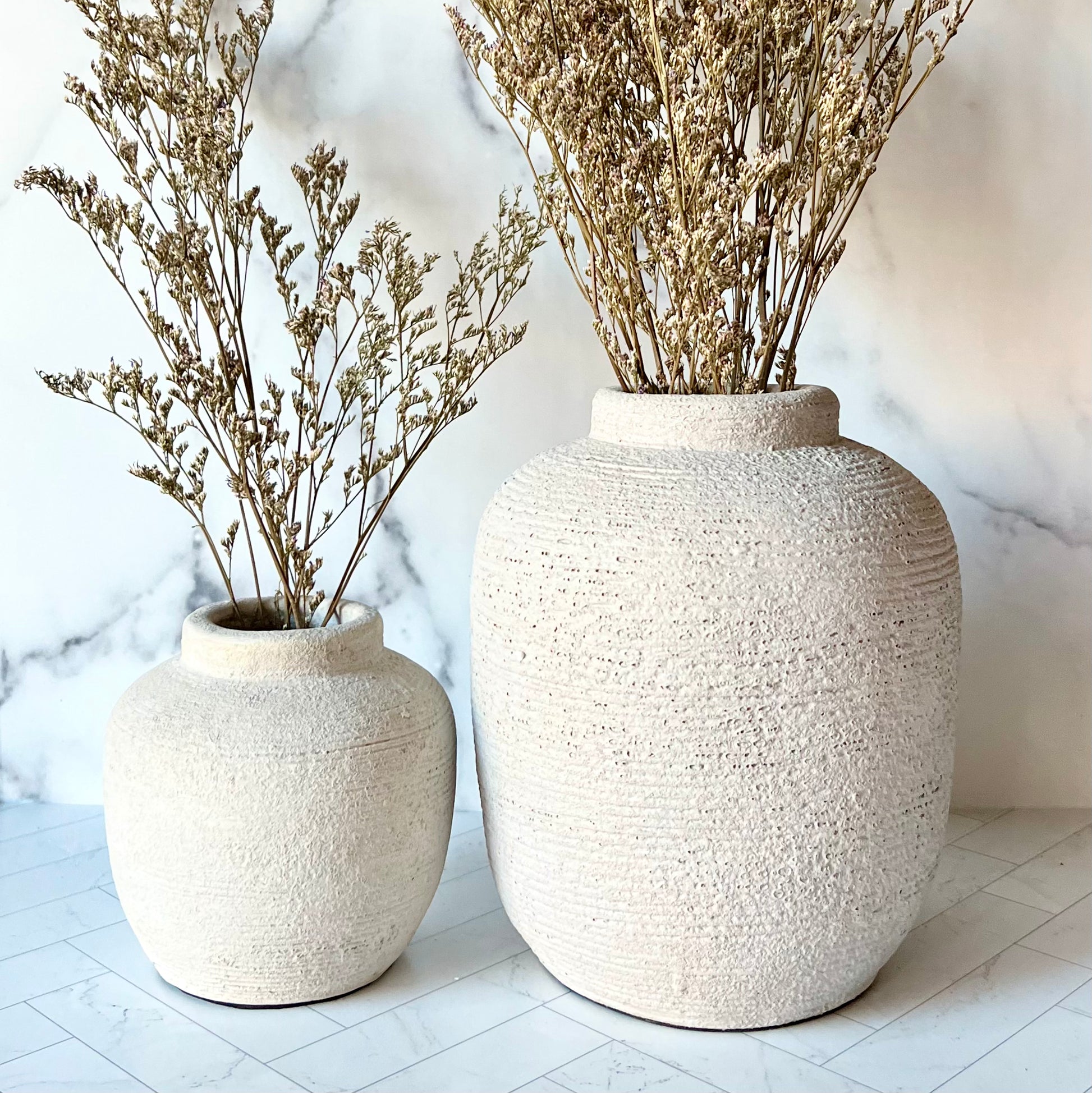 The Petite Concrete Vase next to a larger gray vase to show its size comparison