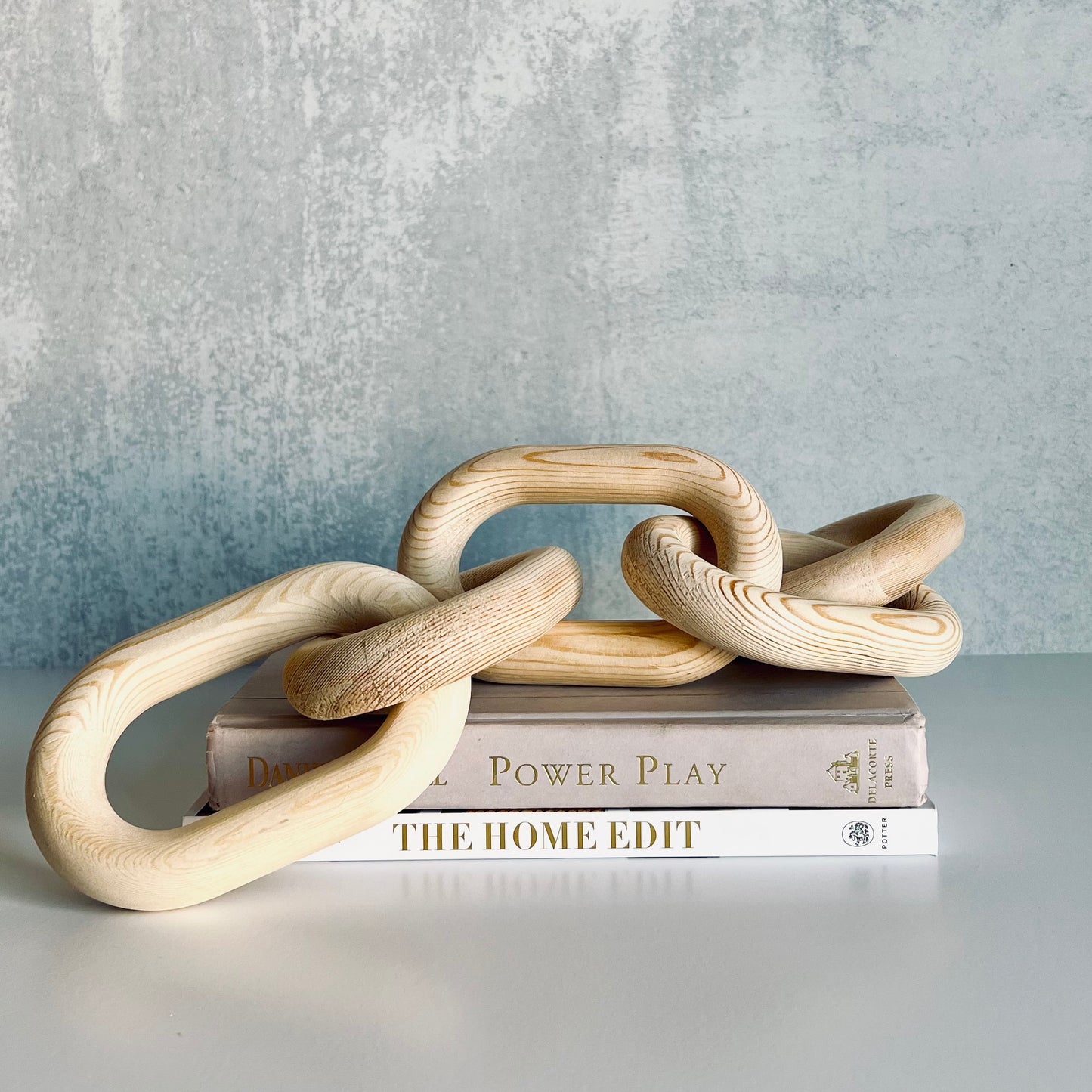 Hand-Carved Blonde Wood Chain on top of a stack of books - The Offbeat Co.