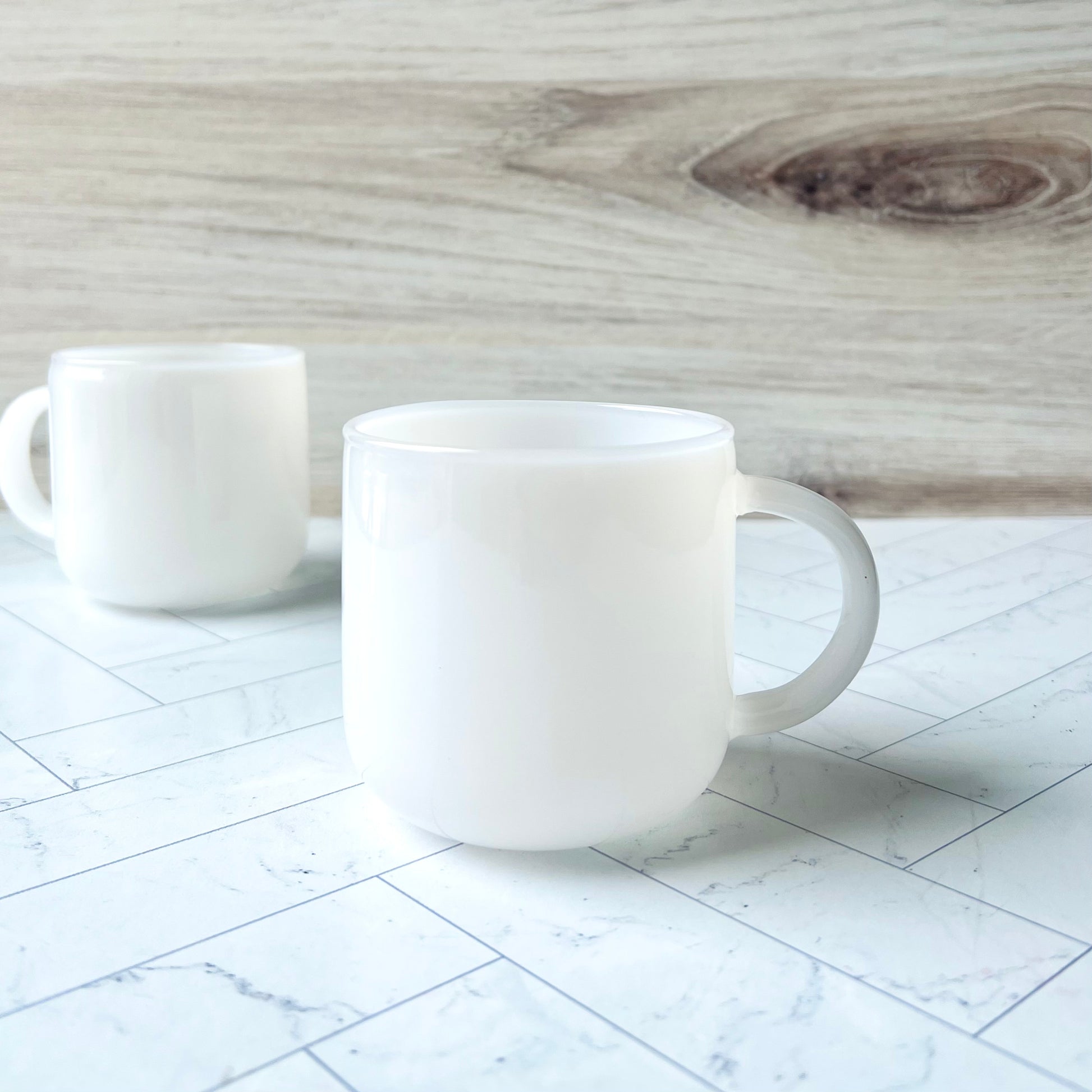 The Glass Mug Set in White shown with one front-and-center and the other in the background