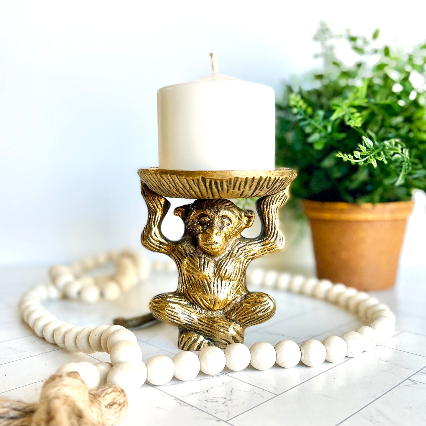 The brass monkey figurine shown with other decorative items on a table